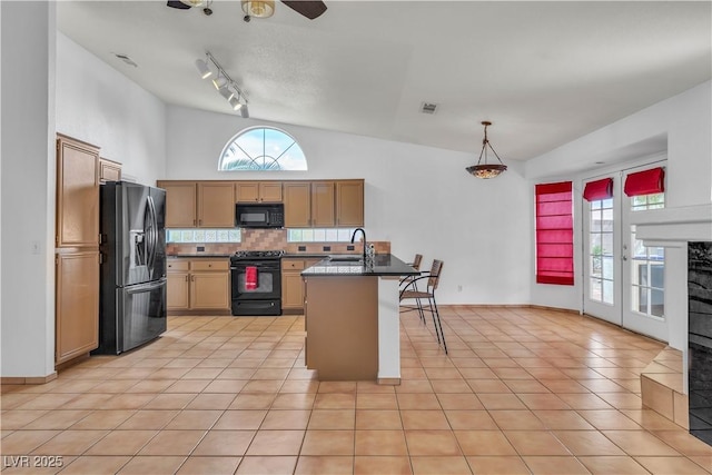 6405 Break Point Ave, Las Vegas, NV 89130 - kitchen featuring black appliances, a sink, a kitchen bar, tasteful backsplash, and light tile patterned flooring