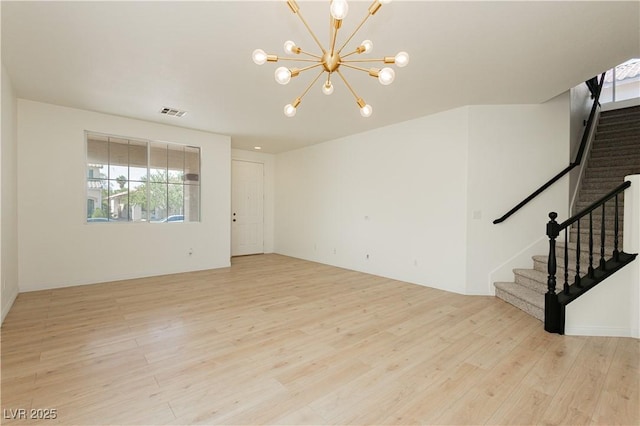8224 Cassis Ct, Las Vegas, NV 89117 - unfurnished room with light wood-style floors, a chandelier, and stairs