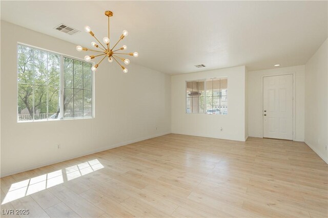 8224 Cassis Ct, Las Vegas, NV 89117 - spare room featuring healthy amount of natural light, a chandelier, and light wood-type flooring