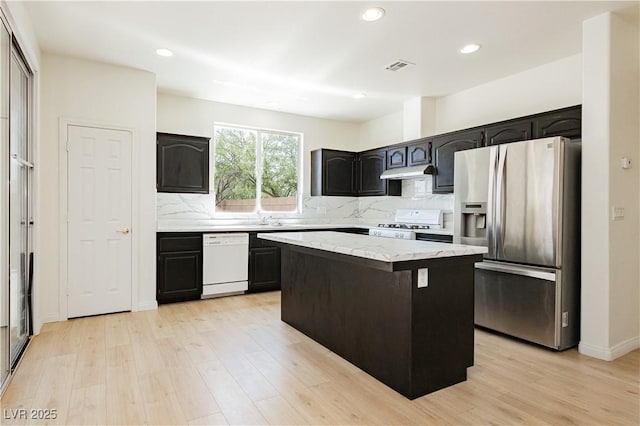 8224 Cassis Ct, Las Vegas, NV 89117 - kitchen with stainless steel refrigerator with ice dispenser, white dishwasher, range, under cabinet range hood, and light wood-type flooring
