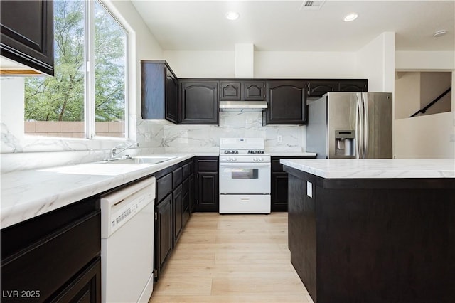 8224 Cassis Ct, Las Vegas, NV 89117 - kitchen featuring white appliances, under cabinet range hood, a sink, plenty of natural light, and recessed lighting