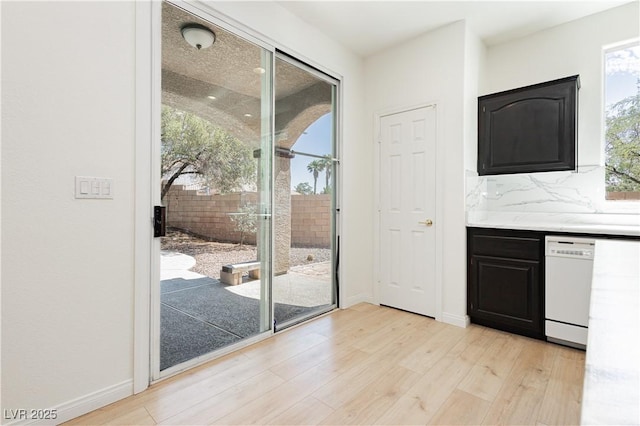 8224 Cassis Ct, Las Vegas, NV 89117 - kitchen with light wood-type flooring, dishwasher, dark cabinets, light countertops, and baseboards