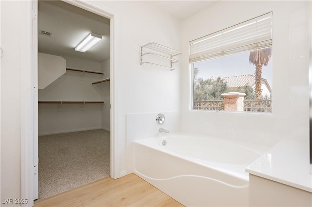 8224 Cassis Ct, Las Vegas, NV 89117 - bathroom with a garden tub, wood finished floors, and a walk in closet