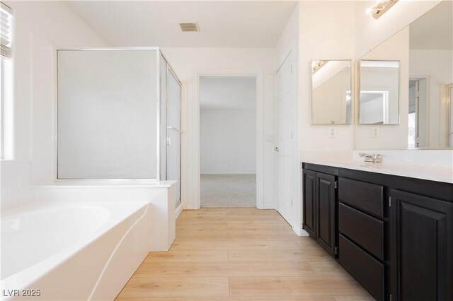 8224 Cassis Ct, Las Vegas, NV 89117 - full bath featuring vanity, a stall shower, a bath, and wood finished floors