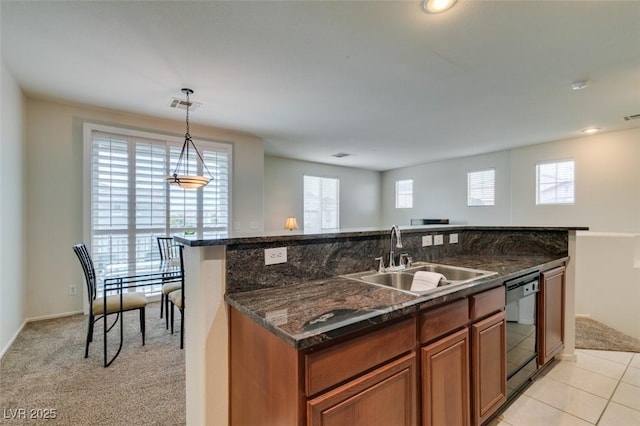 1370 Crystal Hill Ln Unit 3, Henderson, NV 89012 - kitchen with dishwasher, brown cabinetry, a center island with sink, decorative light fixtures, and dark stone counters