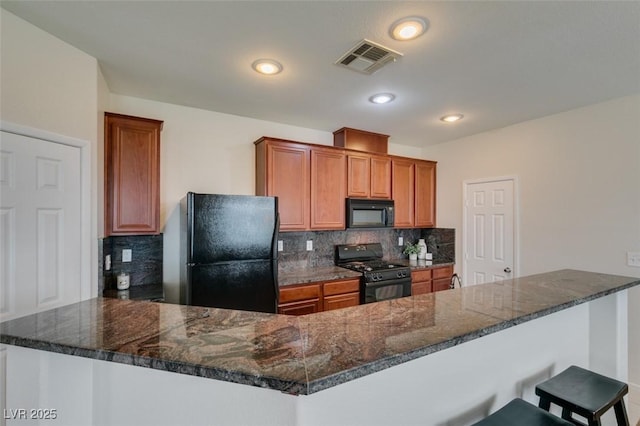 1370 Crystal Hill Ln Unit 3, Henderson, NV 89012 - kitchen featuring black appliances, backsplash, a breakfast bar, brown cabinetry, and dark stone countertops