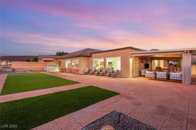 20 Kittansett Loop, Henderson, NV 89052 - back of property at dusk with a patio, stucco siding, and a yard