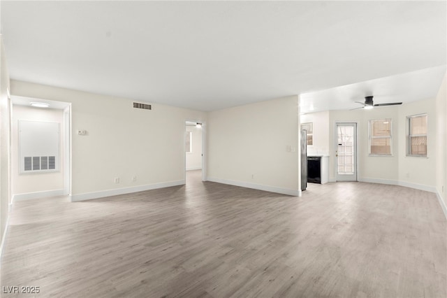 7566 Glowing Ember Ct Unit 101, Las Vegas, NV 89130 - unfurnished living room with a ceiling fan, light wood finished floors, and baseboards
