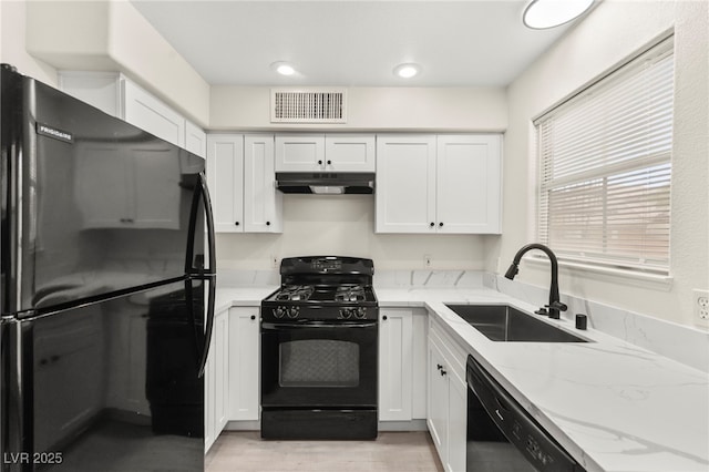 7566 Glowing Ember Ct Unit 101, Las Vegas, NV 89130 - kitchen with black appliances, under cabinet range hood, a sink, white cabinetry, and light stone counters