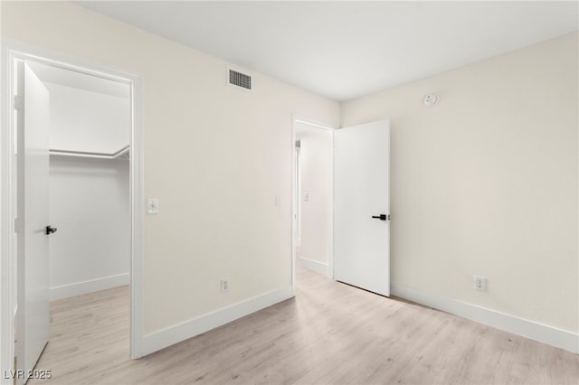 7566 Glowing Ember Ct Unit 101, Las Vegas, NV 89130 - unfurnished bedroom featuring wood finished floors, a spacious closet, and baseboards