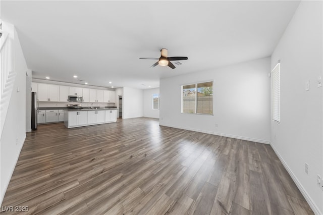 9839 Berkley Brook Ct, Las Vegas, NV 89141 - unfurnished living room featuring ceiling fan, recessed lighting, dark wood-type flooring, and baseboards