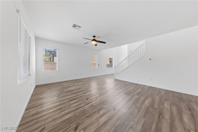 9839 Berkley Brook Ct, Las Vegas, NV 89141 - unfurnished living room featuring stairs, wood finished floors, a ceiling fan, and baseboards