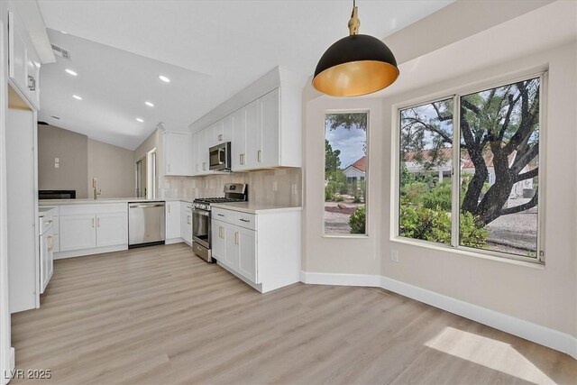 8513 Festival Dr, Las Vegas, NV 89134 - kitchen with appliances with stainless steel finishes, lofted ceiling, baseboards, light wood-style flooring, and recessed lighting