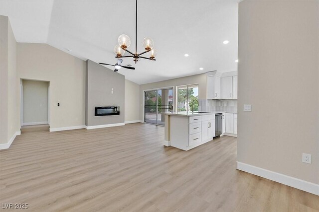 8513 Festival Dr, Las Vegas, NV 89134 - kitchen featuring a chandelier, vaulted ceiling, open floor plan, light countertops, and white cabinetry