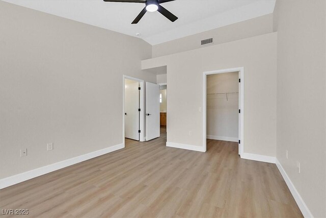 8513 Festival Dr, Las Vegas, NV 89134 - unfurnished bedroom featuring vaulted ceiling, a spacious closet, light wood finished floors, baseboards, and a closet