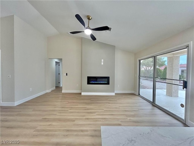 8513 Festival Dr, Las Vegas, NV 89134 - unfurnished living room with lofted ceiling, ceiling fan, light wood finished floors, baseboards, and a glass covered fireplace