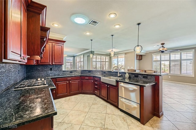 4750 Fiore Bella Blvd, Las Vegas, NV 89135 - kitchen with reddish brown cabinets, crown molding, ceiling fan, decorative backsplash, and pendant lighting