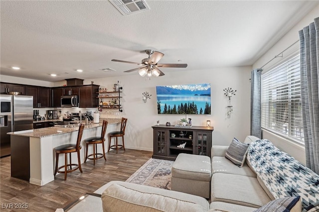 6807 Satin Silver Ct, North Las Vegas, NV 89086 - living room with wood finished floors, ceiling fan, recessed lighting, baseboards, and a textured ceiling