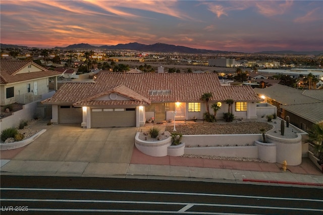 1060 Calico Ridge Dr, Henderson, NV 89011 - view of front facade featuring a tile roof, an attached garage, concrete driveway, and a mountain view