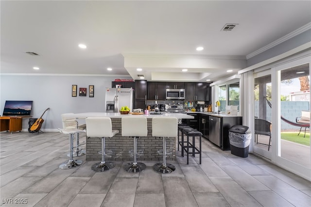 3400 Sioux Way, Las Vegas, NV 89169 - kitchen with appliances with stainless steel finishes, ornamental molding, a breakfast bar, light countertops, and a center island