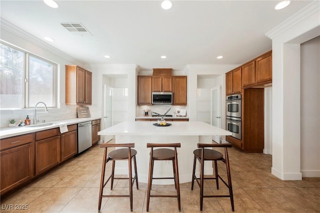 7466 Matilda St, Las Vegas, NV 89113 - kitchen featuring stainless steel appliances, a sink, brown cabinets, a center island, and a kitchen bar