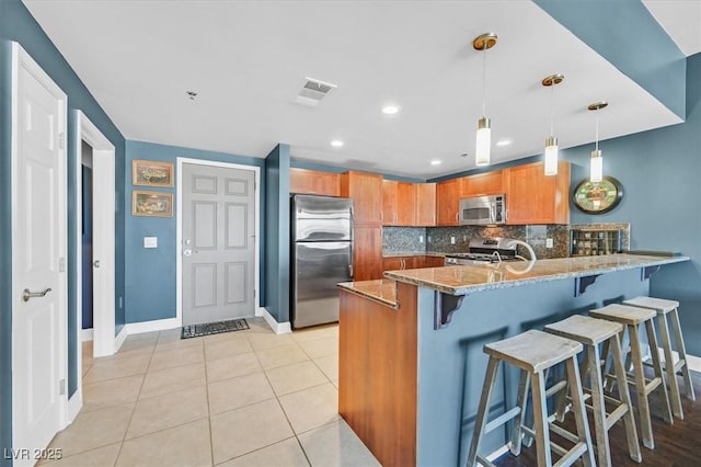 150 Las Vegas Blvd Unit 1004, Las Vegas, NV 89101 - kitchen featuring stainless steel appliances, baseboards, a peninsula, light stone counters, and backsplash