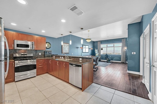 150 Las Vegas Blvd Unit 1004, Las Vegas, NV 89101 - kitchen with appliances with stainless steel finishes, a sink, a peninsula, light tile patterned floors, and tasteful backsplash