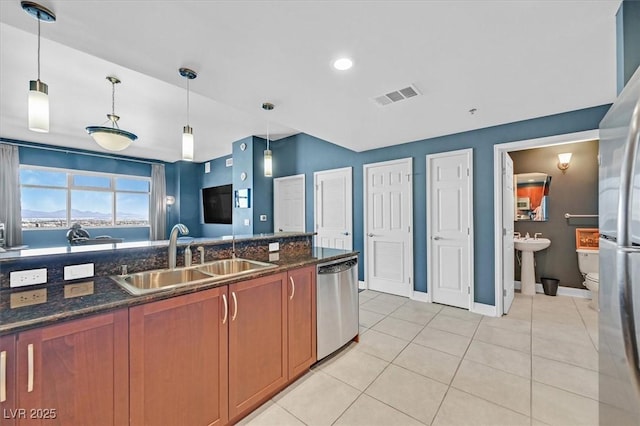 150 Las Vegas Blvd Unit 1004, Las Vegas, NV 89101 - kitchen with a sink, dishwasher, brown cabinetry, baseboards, and light tile patterned floors