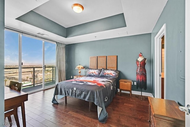 150 Las Vegas Blvd Unit 1004, Las Vegas, NV 89101 - bedroom featuring wood finished floors, a raised ceiling, expansive windows, access to exterior, and baseboards