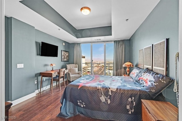 150 Las Vegas Blvd Unit 1004, Las Vegas, NV 89101 - bedroom featuring wood finished floors, baseboards, expansive windows, and a raised ceiling