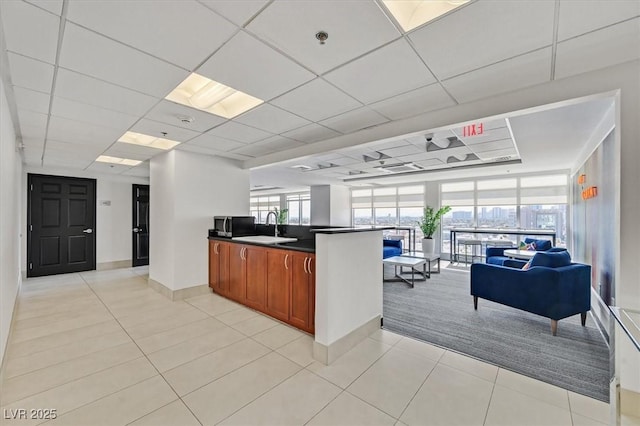 150 Las Vegas Blvd Unit 1004, Las Vegas, NV 89101 - kitchen featuring open floor plan, a sink, dark countertops, brown cabinetry, and light tile patterned floors