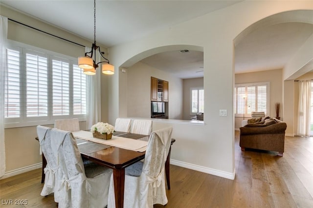 2418 Brockton Way, Henderson, NV 89074 - dining area with arched walkways, wood finished floors, and a chandelier