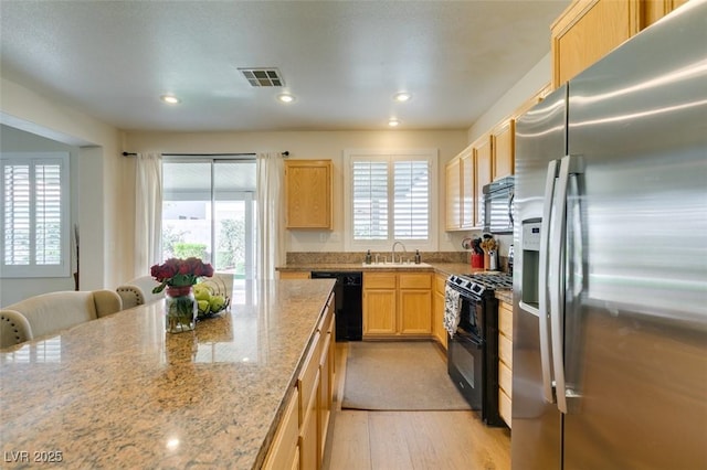 2418 Brockton Way, Henderson, NV 89074 - kitchen featuring black appliances, light brown cabinetry, light wood-style floors, recessed lighting, and light stone counters