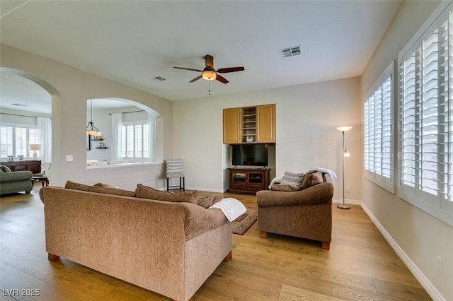 2418 Brockton Way, Henderson, NV 89074 - living area featuring light wood-type flooring, a ceiling fan, and arched walkways