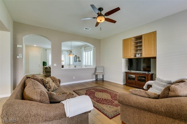 2418 Brockton Way, Henderson, NV 89074 - living room featuring arched walkways, ceiling fan, and light wood-style floors