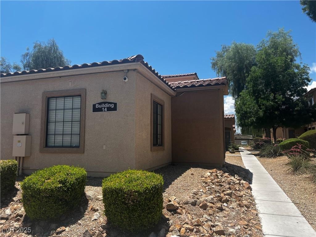2041 Hussium Hills St Unit 104, Las Vegas, NV 89108 - view of side of property featuring a tiled roof and stucco siding