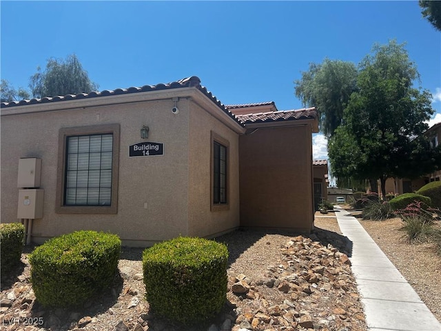 2041 Hussium Hills St Unit 104, Las Vegas, NV 89108 - view of side of property featuring a tiled roof and stucco siding