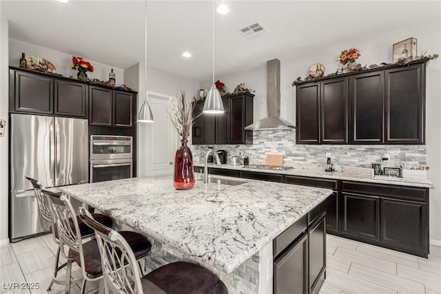 5616 Silver Cascade Ave, Las Vegas, NV 89131 - kitchen featuring stainless steel appliances, wall chimney range hood, a sink, decorative backsplash, and recessed lighting