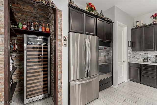5616 Silver Cascade Ave, Las Vegas, NV 89131 - kitchen featuring appliances with stainless steel finishes, wine cooler, dark brown cabinets, and decorative backsplash