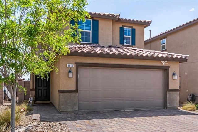 9690 Langden Brook St, Las Vegas, NV 89178 - view of front of home featuring a tiled roof, decorative driveway, stucco siding, and a garage