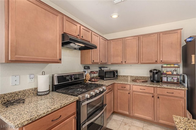 9690 Langden Brook St, Las Vegas, NV 89178 - kitchen with appliances with stainless steel finishes, under cabinet range hood, light stone countertops, light tile patterned floors, and recessed lighting