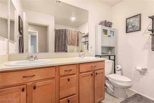 9690 Langden Brook St, Las Vegas, NV 89178 - bathroom with double vanity, toilet, baseboards, and a shower with shower curtain