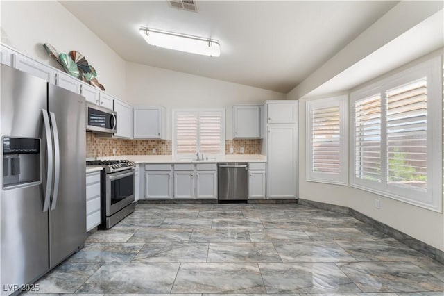1740 Leaning Pine Way, Las Vegas, NV 89128 - kitchen with stainless steel appliances, lofted ceiling, light countertops, tasteful backsplash, and white cabinets