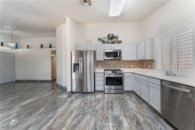 1740 Leaning Pine Way, Las Vegas, NV 89128 - kitchen with appliances with stainless steel finishes, a sink, decorative backsplash, light countertops, and white cabinets