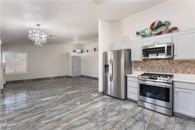 1740 Leaning Pine Way, Las Vegas, NV 89128 - kitchen with appliances with stainless steel finishes, a chandelier, decorative backsplash, light countertops, and lofted ceiling