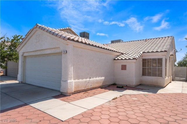 1740 Leaning Pine Way, Las Vegas, NV 89128 - view of front of house featuring stucco siding, a tiled roof, a chimney, an attached garage, and concrete driveway