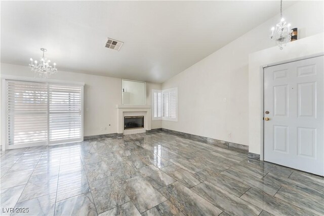 1740 Leaning Pine Way, Las Vegas, NV 89128 - unfurnished living room featuring a chandelier, plenty of natural light, light marble finish floors, a glass covered fireplace, and lofted ceiling