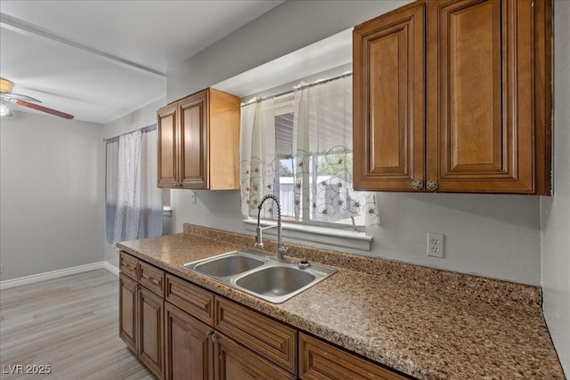 808 Reynolds Ave, North Las Vegas, NV 89030 - kitchen featuring a sink, a ceiling fan, brown cabinetry, and plenty of natural light