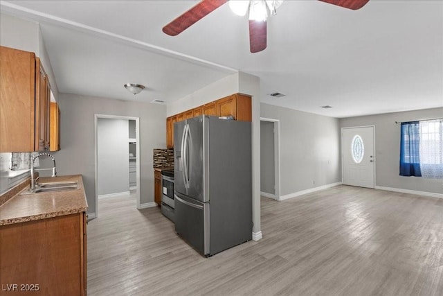 808 Reynolds Ave, North Las Vegas, NV 89030 - kitchen with appliances with stainless steel finishes, a sink, brown cabinets, and a ceiling fan
