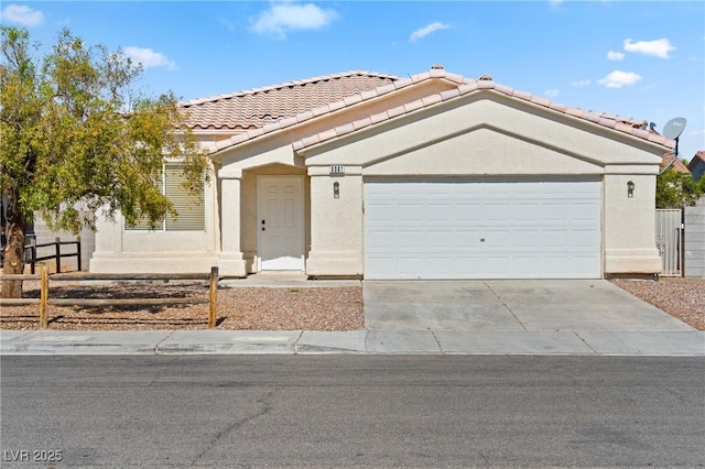 5307 Wild Orchid St, North Las Vegas, NV 89031 - mediterranean / spanish home with a tiled roof, concrete driveway, an attached garage, and stucco siding